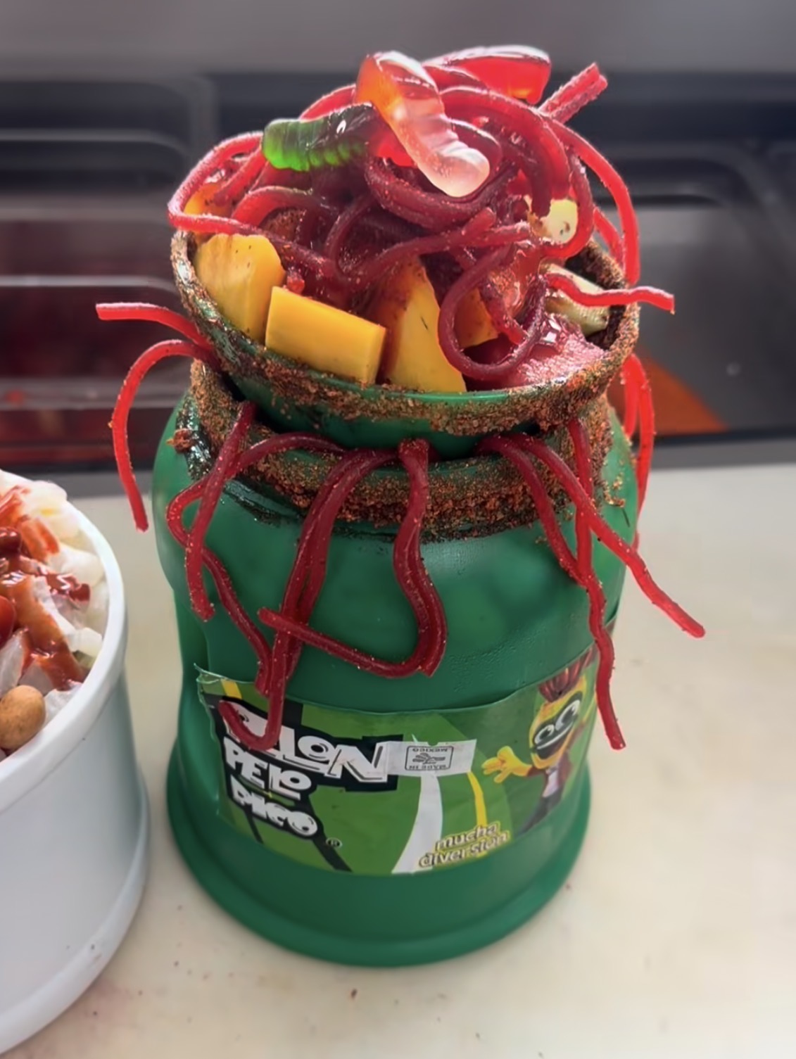 Mangoneada en vaso Pelón Pelo Rico con mango, chamoy y tiras de tamarindo