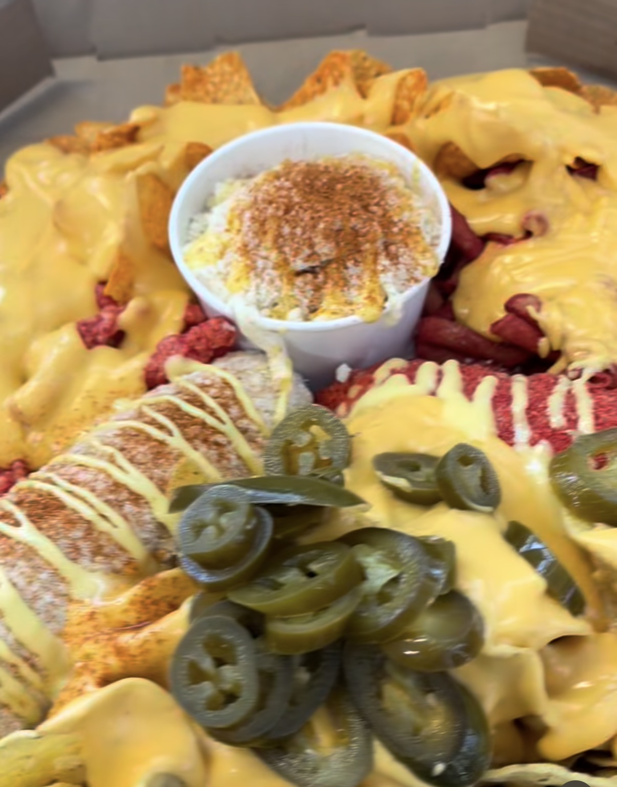 Charola de botana con nachos con queso, chetos, salchicha y jalapeños